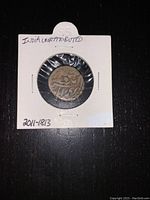 Photo of one side of the coin displaying inscriptions and some numeric figures, mounted in a protective holder with label indicating 'India Unattributed' and date range '2011-1813'