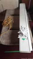 Flat dolly carpeted surface and length with attached yellow rope visible.