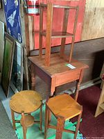Four wooden side tables of different sizes and shapes stacked and grouped together showing their styles and construction details.