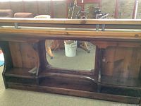 Front and side view of dark stained wooden water bed headboard with built-in drawers and open compartments, showing construction and wood grain.