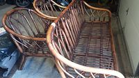 Wicker couch and 2 chairs grouped together showing overall size and style.