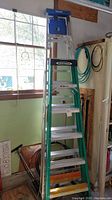 Overall side view of two Werner aluminum ladders, one 6' and one 8' tall, showing ladder height and general condition
