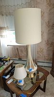 Overview of the two lamps on a glass top table, showing the difference in size and overall style.