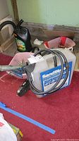 Front and side angles of the gray and blue portable sand blaster tank with attached hose and gun nozzle.