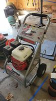 Front view of the Coleman Powermate Clean Machine pressure washer showing engine and control panel with brand decals.