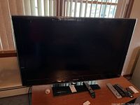 Front view of Samsung 46-inch LED TV with remote on stand