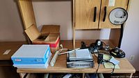 Wood desk with Uniden Bearcat BC355N scanner in original box, paper reams, Smart Drive HD4-U2, and various cables and office supplies