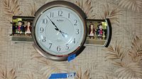 Front view of the 16 inch diameter Small World Rhythm wall clock mounted on wall.