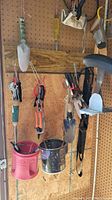 Photo of hanging small hand shovels, trowels, pruning shears/clippers, and small garden tools on pegboard