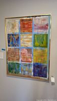 Full view of large abstract oil painting on canvas with grid of colorful blocks in gold frame