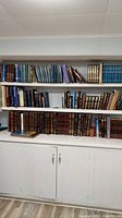 Shelf view showing multiple Hebrew books across three tiers