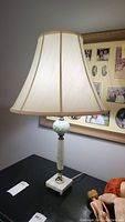 Desk lamp with marble-like base, twisted glass column, and white shade with beige trim