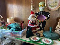Full lot view showing Santa, skeleton, green curtains in bin, candy cane decorations, and clocks.