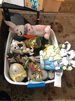 White tub filled with various Easter themed decorations including plush and ceramic figurines.
