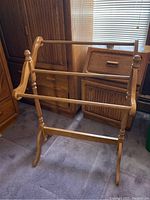 Front view of wood quilt rack showing three horizontal bars and turned finials
