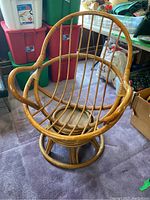 Rattan swivel chair front view showing circular base and vertical rattan rods.