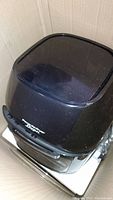 Black PowerAirFryer oven with transparent top lid inside cardboard box.