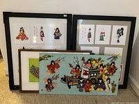 Overview of lot showing two black frames, one wooden frame and unframed pastel green collage