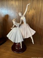 Front view of the figurine showing both dancers and wood-tone base