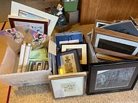 Three plastic tubs on floor filled with unframed rolled prints, loose mats, backing boards and assembled framed prints