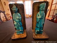 Front view of both green glazed ceramic figurine bookends mounted on metal bases