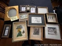 All eleven photo frames and pictures arranged on a black surface showing variety in frame shapes, sizes, and artwork styles, including sketches and the beaded mosaic.