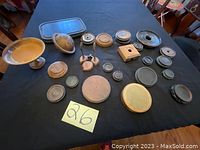 Photo showing various wooden and metal Asian stands and a small tray arranged on a black cloth.