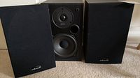 Pair of Polk Audio Dynamic Balance YC-119A speakers with one grille removed showing the drivers, the other with grille on