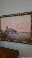 Full view of the framed oil on canvas painting showing the building, shore, and sky in muted colors.