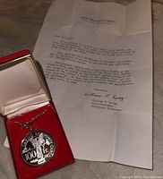 Photo showing pendant on chain in red display box alongside certificate of authenticity letter from Franklin Mint.