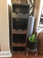 Front view of the grey/silver IKEA wine rack showing four shelves designed for bottle storage.