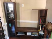 Front view of the modern wood veneer TV stand with glass display cabinet and attached bookcase with books on shelves.