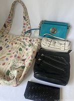 Overview of all six items including floral tote, turquoise and white handbags, black wallet, and keychain tassel.