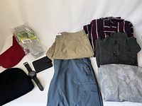Full lot showing clothing items including sweaters, pants, socks, hats, wallet, and watch.