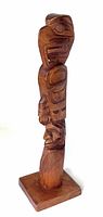 Side view of the 13-inch tall wooden totem pole showing eagle and man figures carved vertically and mounted on a square wooden base.