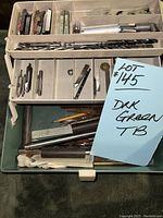 Top view of dark green toolbox insert with drill bits and accessories organized in compartments.