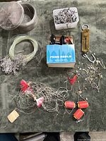 Various fishing tackle and supplies including Penn reel in box, hooks, leader lines, lures, floats, and brass fish weight scale