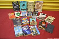 Books arranged on floor with titles visible, showing a mix of poetry, classic literature, and science fiction.