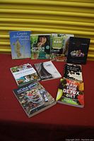 Photo shows 8 books arranged against a yellow shutter background, covers visible.