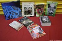 Seven books laid out on red surface with yellow background, topics on nature and animals.