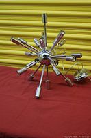 Front view of chrome Sputnik chandelier on red surface with yellow backdrop