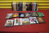 Full view of the DVDs and VHS tapes laid out on a red surface with a yellow background roller shutter.