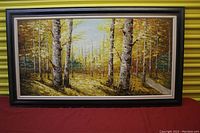Full view of the large oil painting showing the autumn forest scene with birch trees and a wide dark frame.