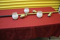 Lamp disassembled with glass shades and brass components on a table