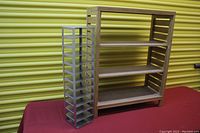 Wooden shelf unit and aluminum slot organizer shown on a red cloth surface with yellow corrugated background.