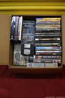 Box of DVDs and VHS tapes with various film titles including "Fantastic Planet" visible on DVD cases and others.