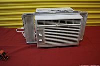 Full view of the Midea window air conditioner showing front grille and control panel with two knobs.