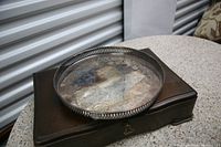 Round Marlboro serving tray on wooden box displaying its size and design, with visible pierced rim detail.