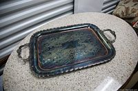 Top view of rectangular serving tray showing floral etching and handles