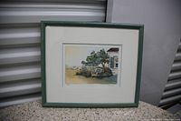 Framed watercolor print showing garden scene with tree, chair, and window, print numbered 113/120 by Alexander Krajewski.